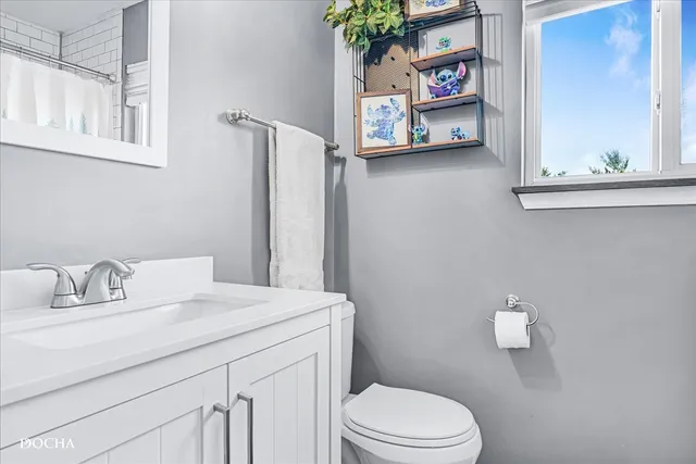 a bathroom with a sink vanity and toilet