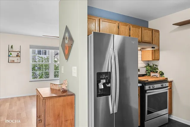 a kitchen with stainless steel appliances a refrigerator and a fireplace
