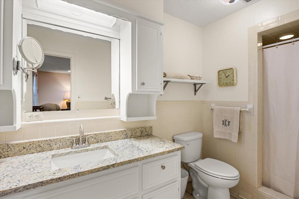 17305 Highway 281 Hico, TX 76457 - Photo 9 of 28 a bathroom with a granite countertop toilet sink and mirror