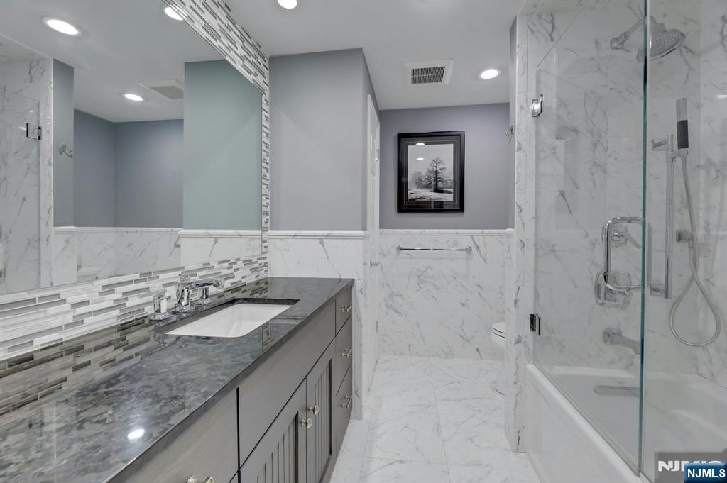 56 Longfellow Lane Mahwah, NJ 07430 - Photo 26 of 33 a bathroom with a granite countertop sink mirror and a bath tub