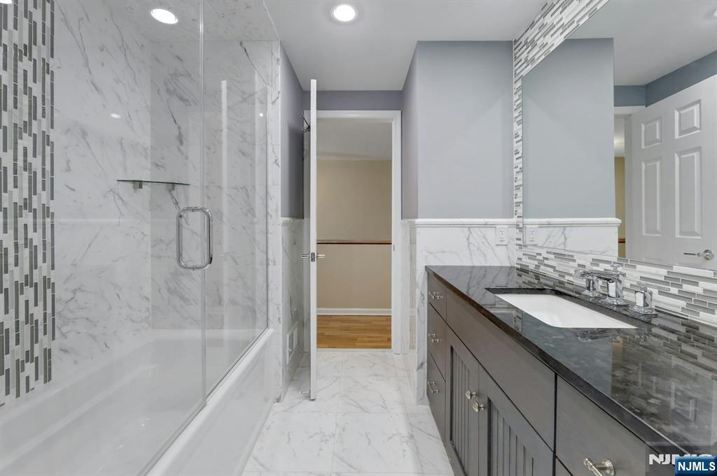 56 Longfellow Lane Mahwah, NJ 07430 - Photo 27 of 33 a bathroom with a granite countertop sink a mirror and a bathtub