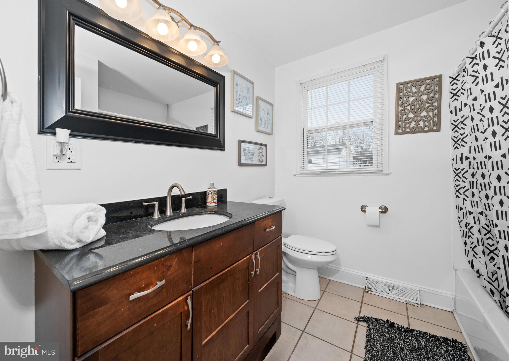 18 George Read Road New Castle, DE 19720 - Photo 23 of 40 a bathroom with a granite countertop toilet sink and mirror