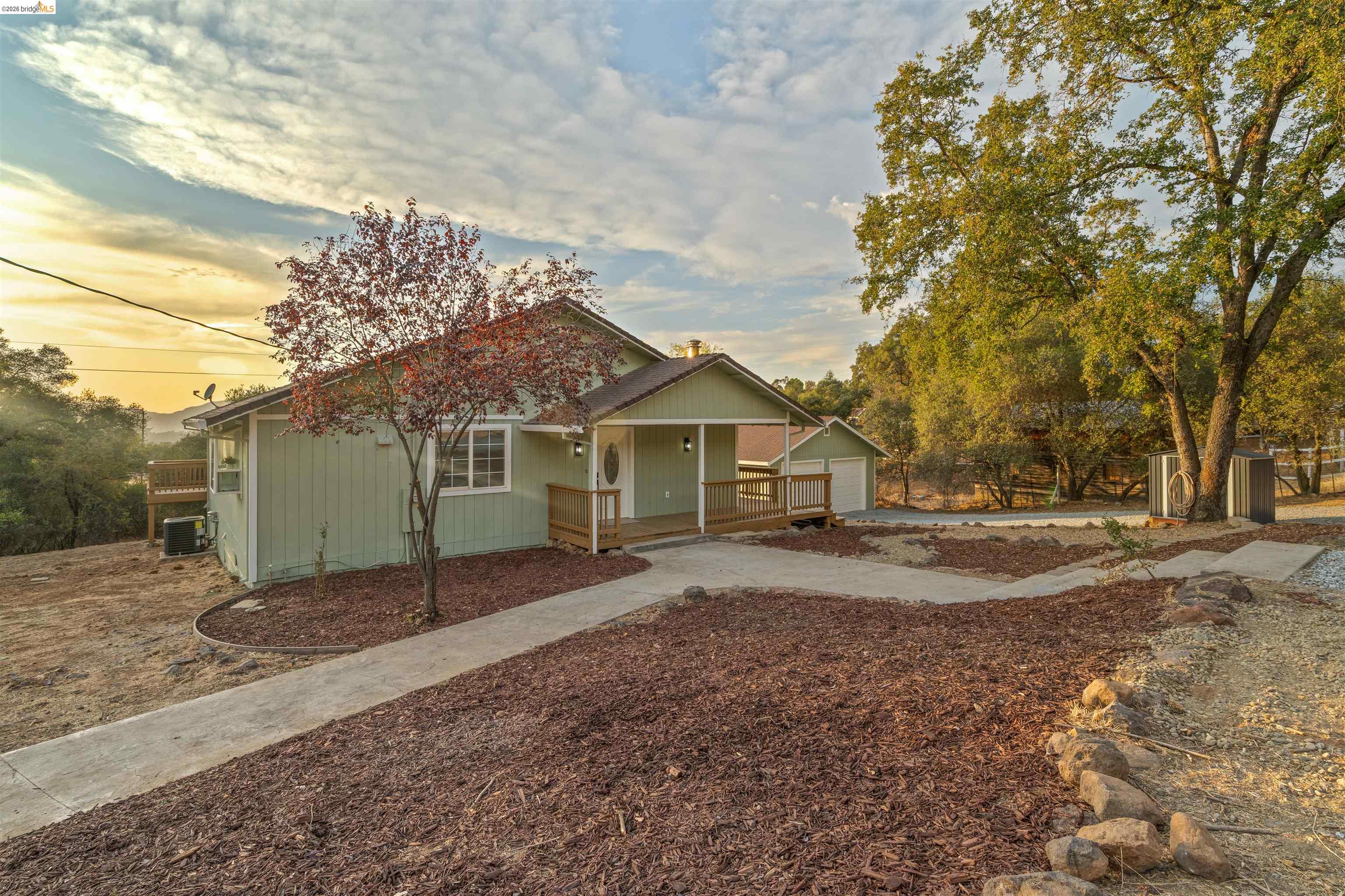 19676 Rawhide Road Sonora, CA 95370 - Photo 39 of 67 Light green exterior with a covered front porch and a detached storage shed