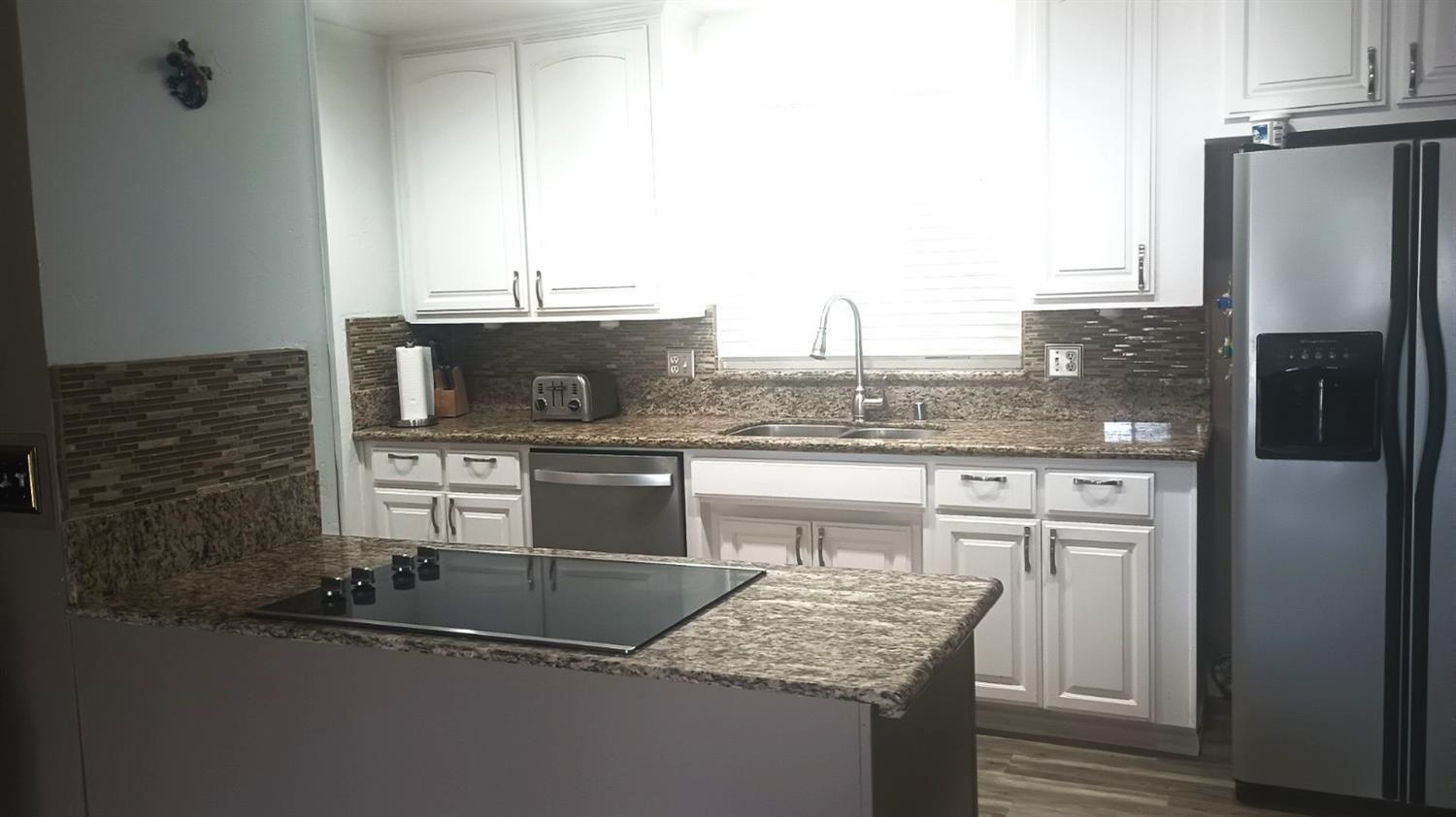 14728 Huntington Road Madera, CA 93636 - Photo 27 of 37 a kitchen with stainless steel appliances granite countertop a sink stove and refrigerator