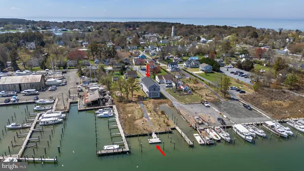 an aerial view of ocean and residential houses with outdoor space