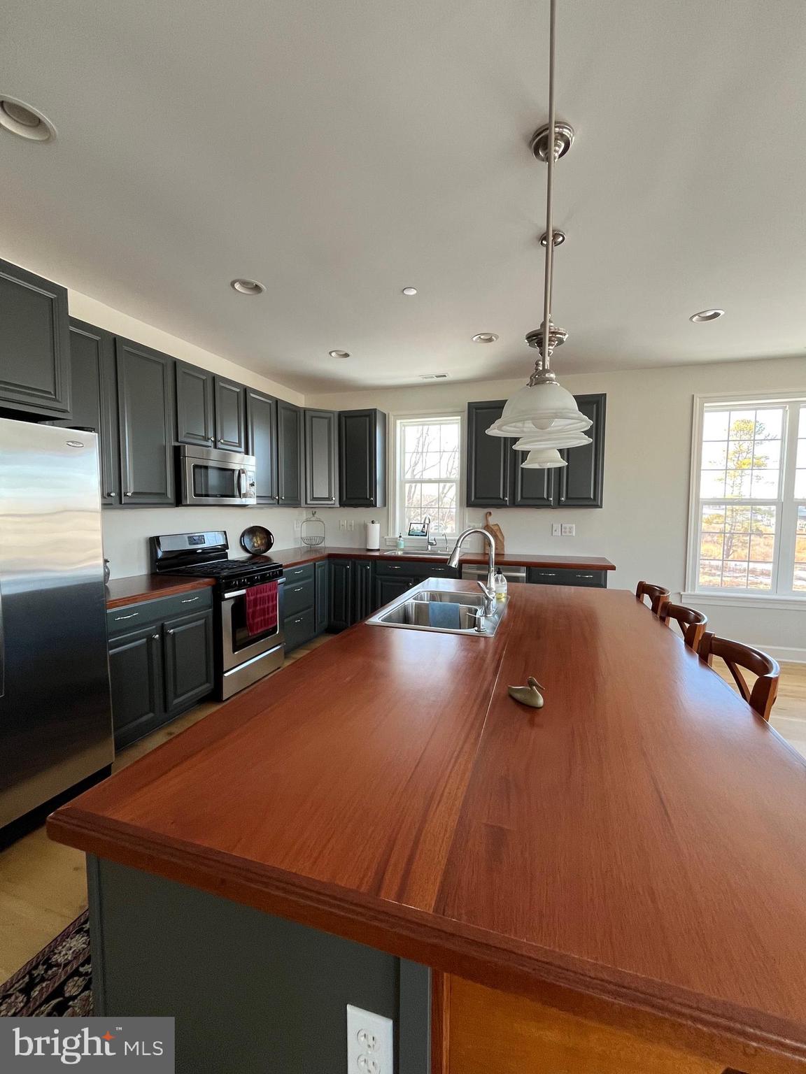21572 Chicken Point Road Tilghman, MD 21671 - Photo 4 of 13 a large kitchen with kitchen island a counter space a sink appliances and cabinets