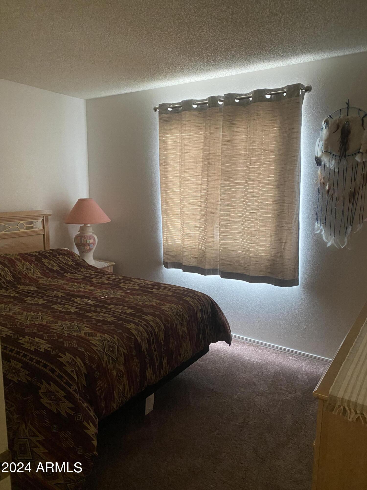 1440 North Idaho Road, Unit 1013 Apache Junction, AZ 85119 - Photo 14 of 40 a bedroom with a bed and a large window