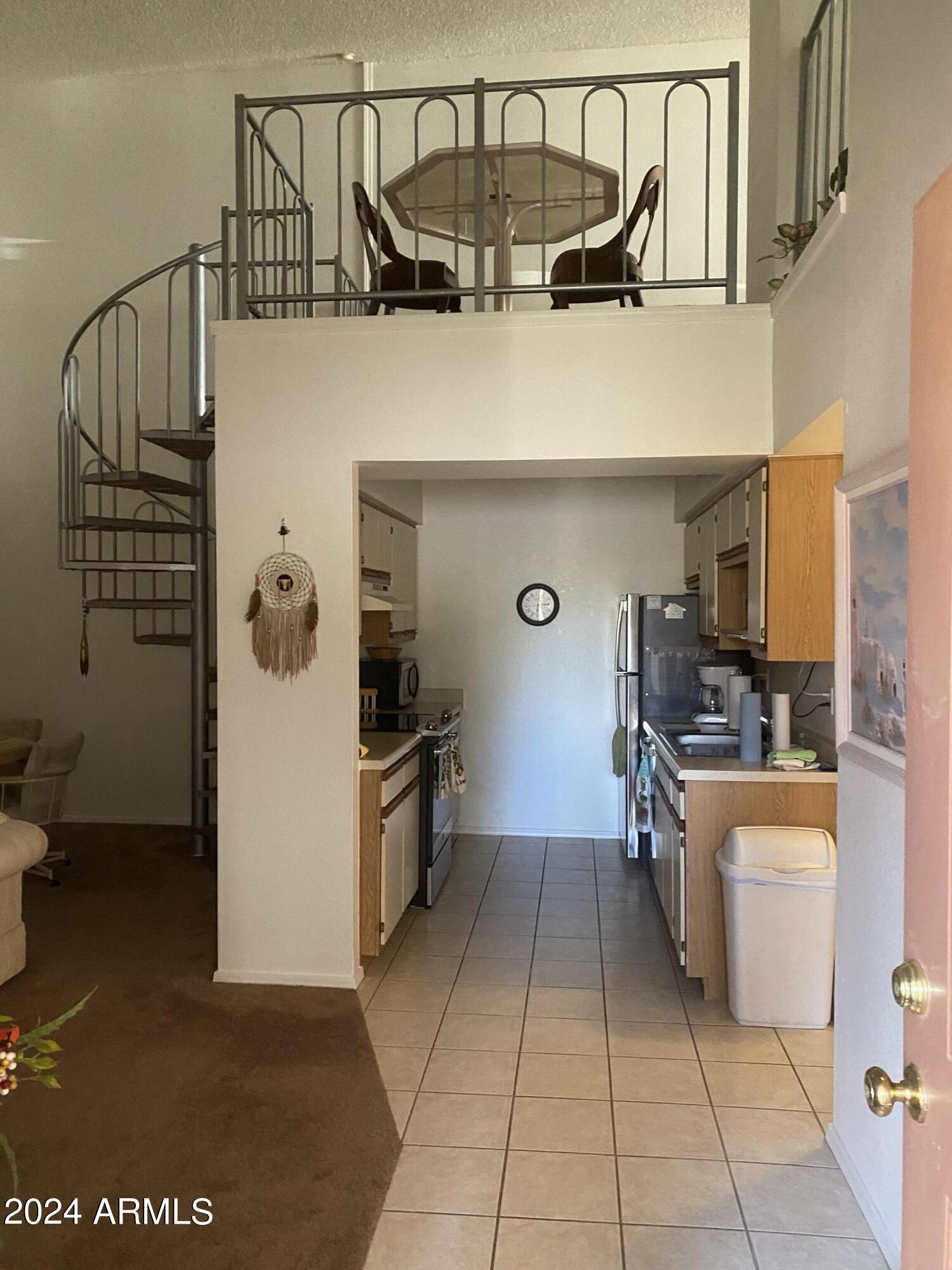1440 North Idaho Road, Unit 1013 Apache Junction, AZ 85119 - Photo 2 of 40 a kitchen with a refrigerator and white cabinets