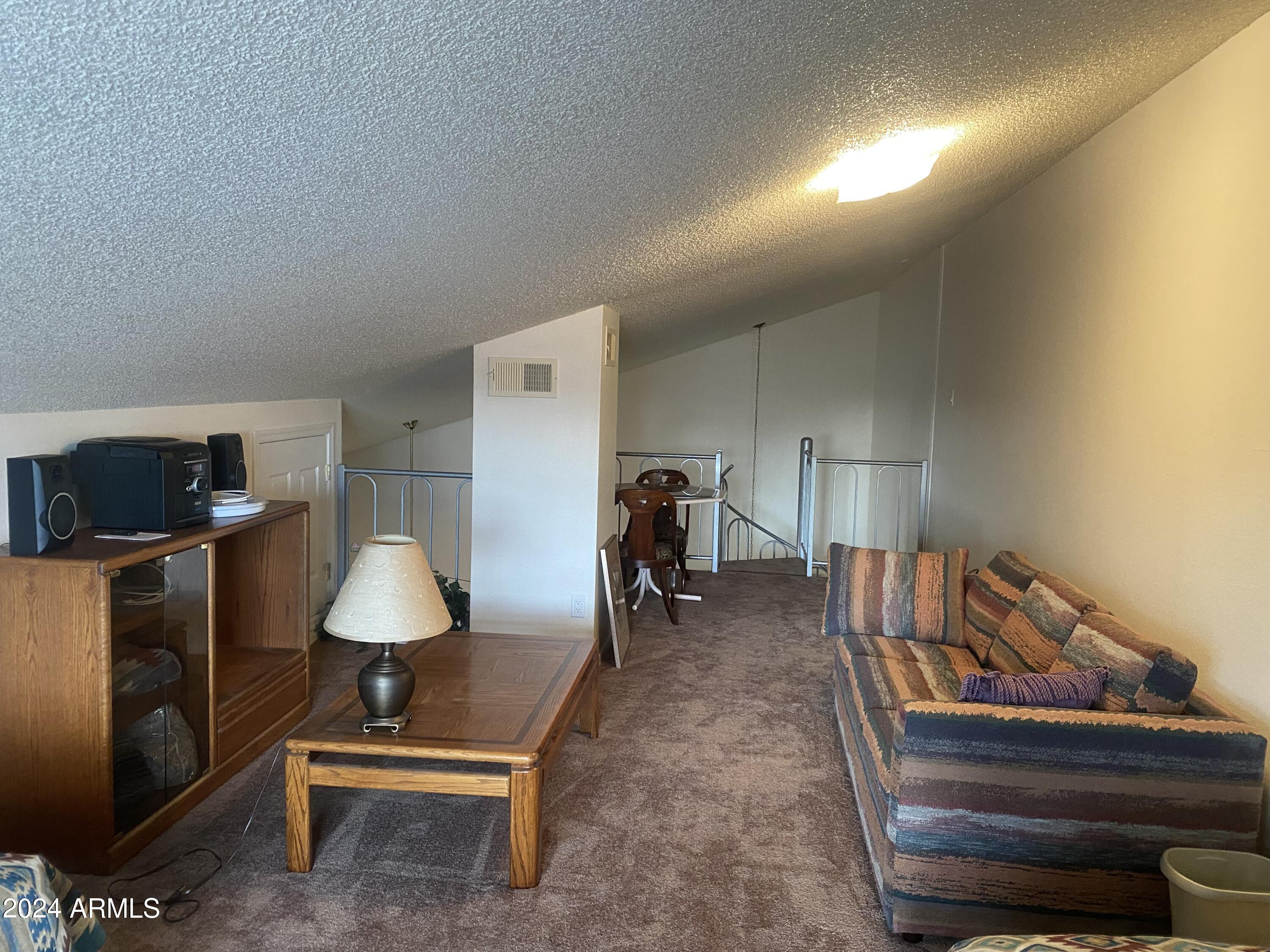 1440 North Idaho Road, Unit 1013 Apache Junction, AZ 85119 - Photo 30 of 40 a living room with furniture a flat screen tv and a lamp