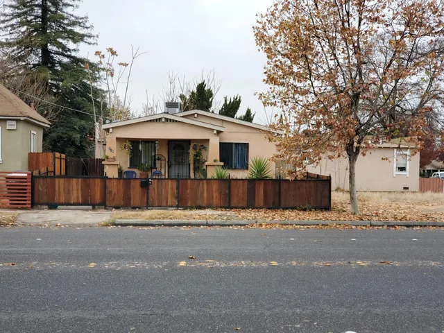 a view of a house with a yard and large tree