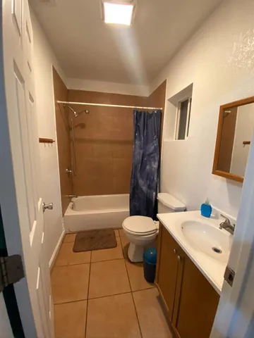 a bathroom with a sink a toilet a mirror a vanity and bathtub