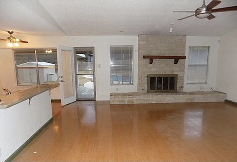 509 Meadowbrook Drive Georgetown, TX 78628 - Photo 12 of 17 A welcoming living space features warm wood flooring and a classic stone fireplace.