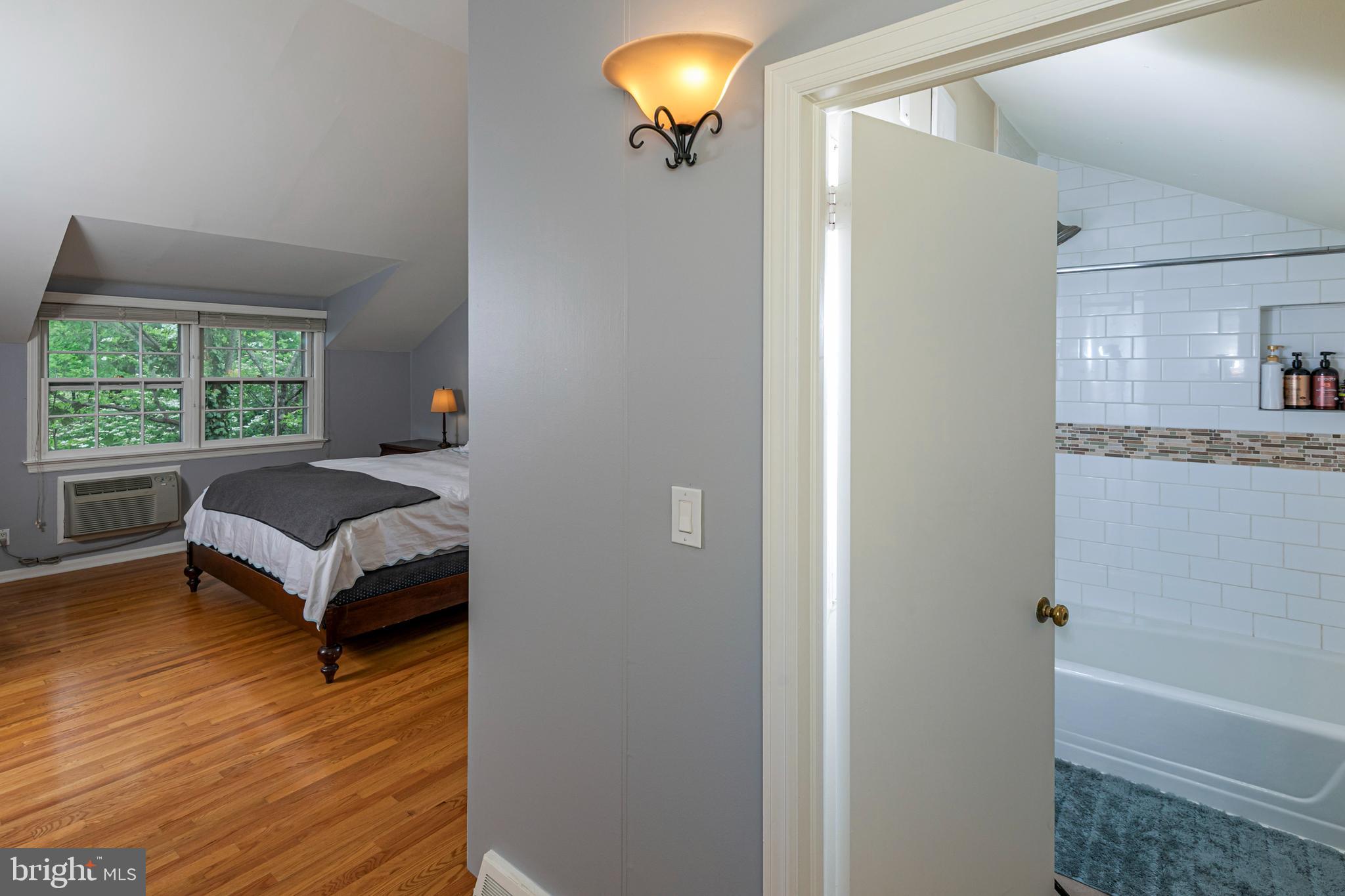 219 Russell Road Princeton, NJ 08540 - Photo 19 of 27 a bedroom with a bed and a night stand with wooden floor