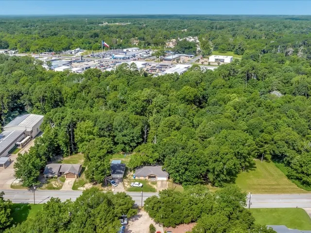 an aerial view of residential houses with outdoor space and trees
