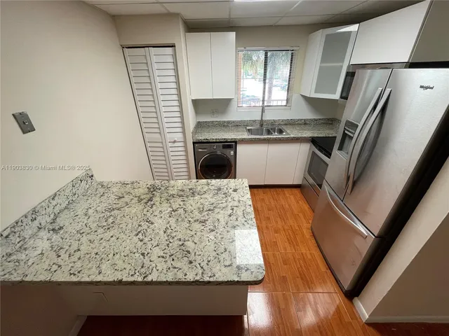a view of kitchen with sink window and refrigerator