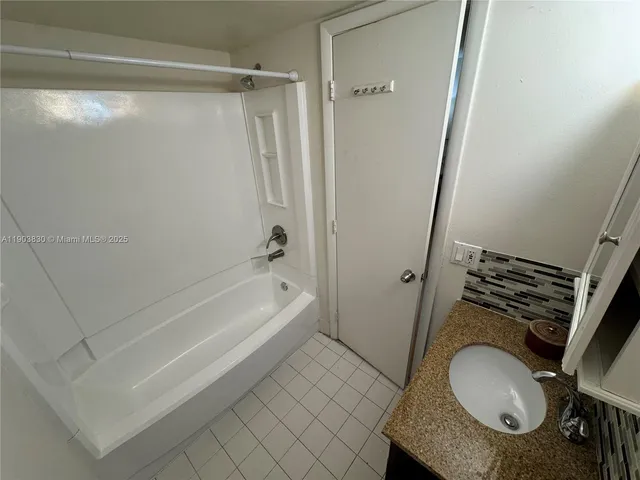 a bathroom with a granite countertop toilet and sink