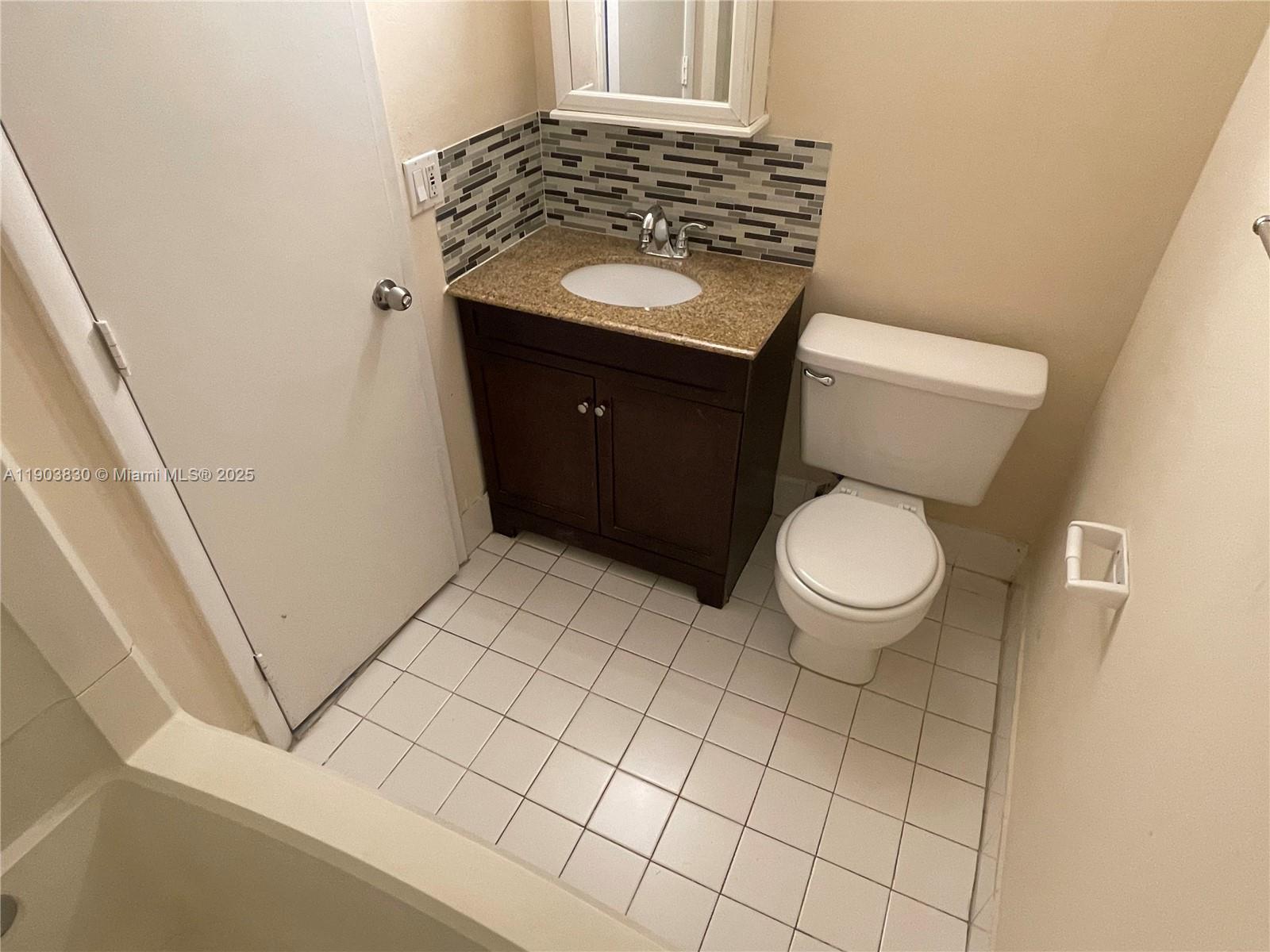 6900 Southwest 39th Street, Unit 206J Davie, FL 33314 - Photo 27 of 34 a bathroom with a granite countertop toilet and sink