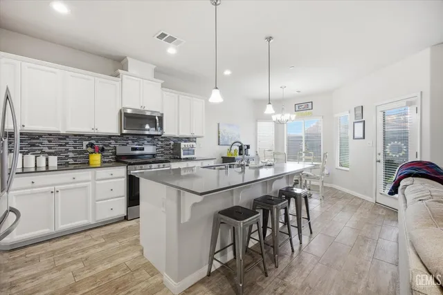 a large kitchen with kitchen island a dining table chairs and a wooden floor