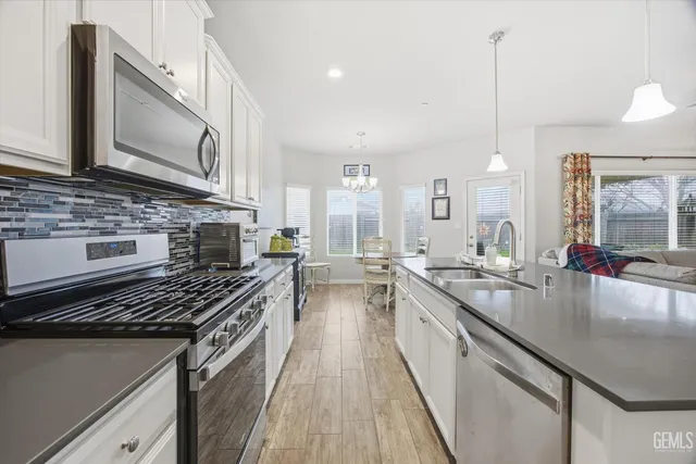 a kitchen with sink stove and cabinets