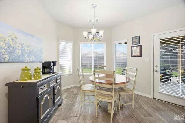 a view of a dining room with furniture a chandelier and wooden floor