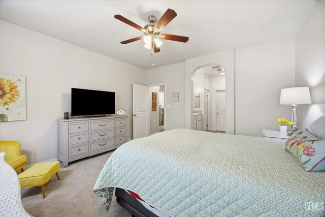 a bedroom with a bed a flat screen tv and dresser