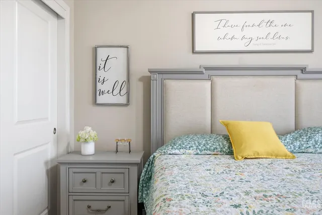 a bedroom with a bed and painting on the wall