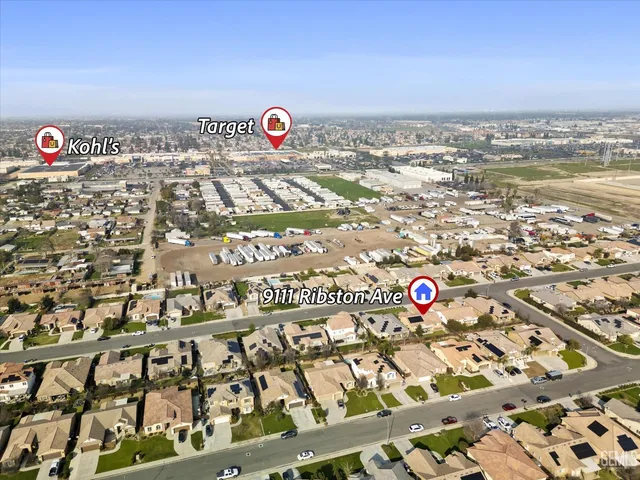 an aerial view of residential houses with outdoor space and parking