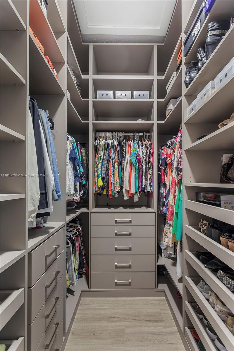 146 Dockside Circle Weston, FL 33327 - Photo 15 of 34 a view of walk in closet with clothes and shoes
