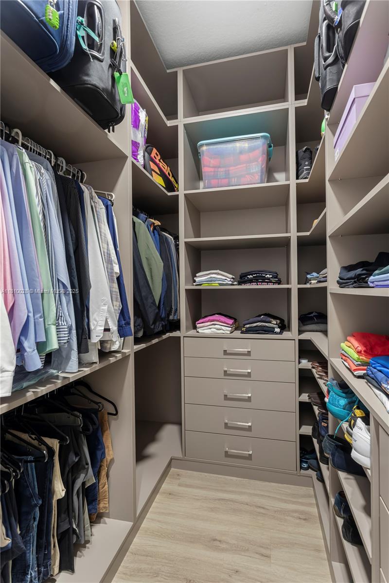 146 Dockside Circle Weston, FL 33327 - Photo 16 of 34 a view of walk in closet with clothes and shoes