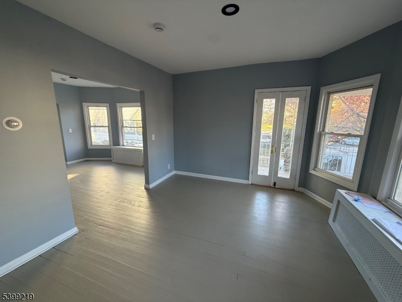 704 Park Avenue Elizabeth, NJ 07208 - Photo 3 of 15 an empty room with wooden floor and windows