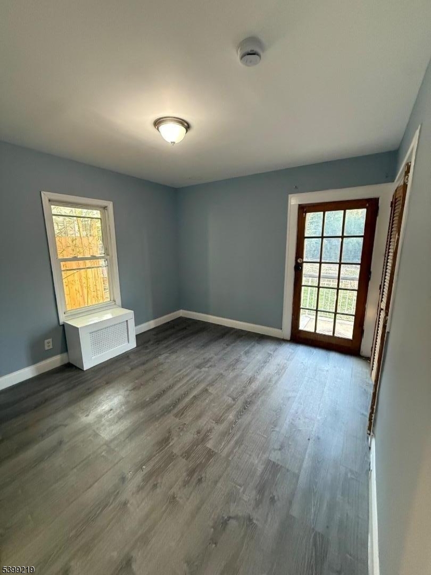 704 Park Avenue Elizabeth, NJ 07208 - Photo 9 of 15 an empty room with wooden floor and windows
