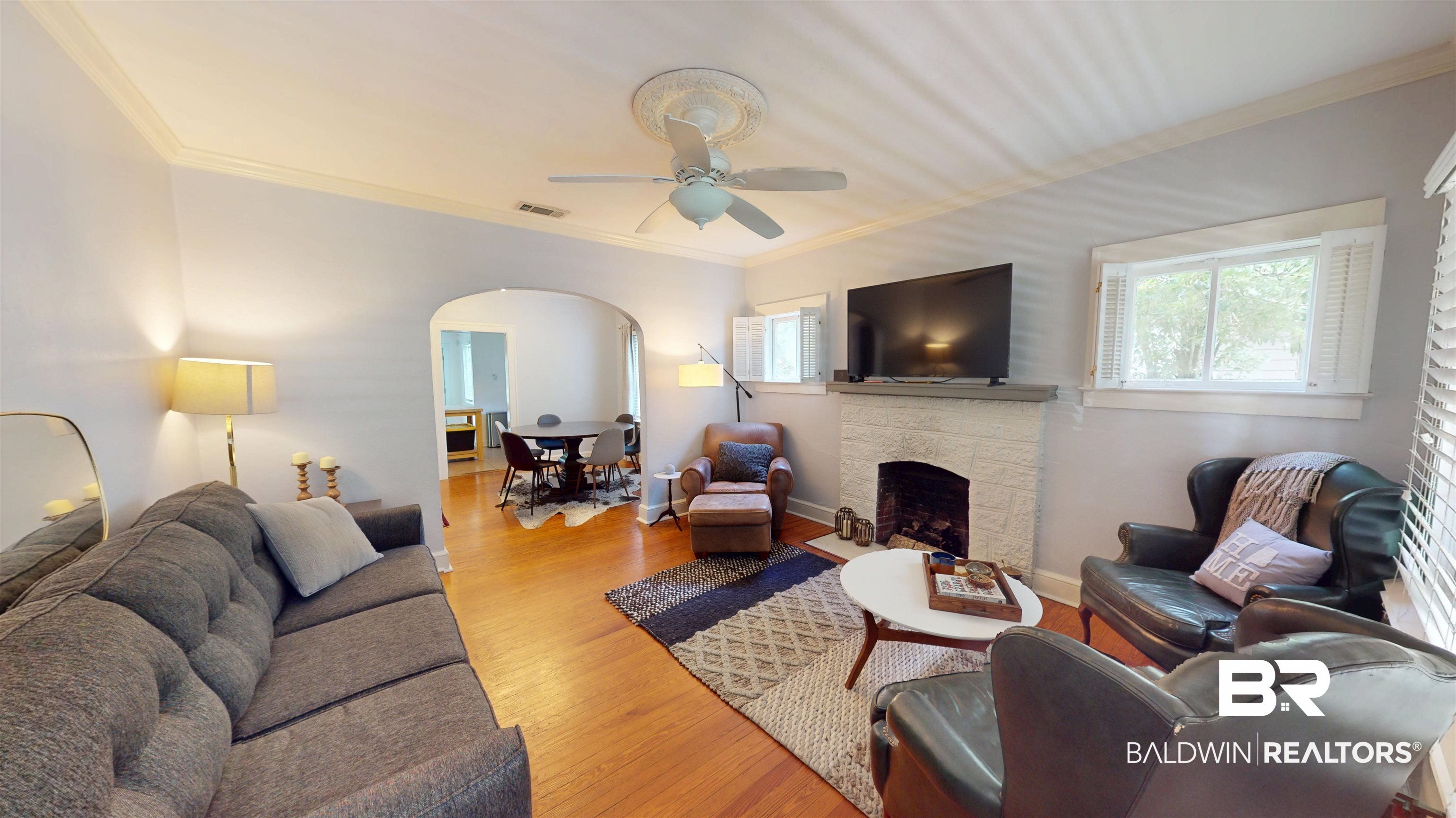 266 Westwood Street Mobile, AL 36606 - Photo 9 of 34 Living area featuring arched walkways, a ceiling fan, ornamental molding, wood finished floors, and a fireplace