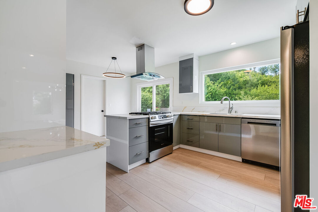 3643 Ballina Canyon Road Encino, CA 91436 - Photo 13 of 47 a kitchen with stainless steel appliances granite countertop a stove a sink and a refrigerator