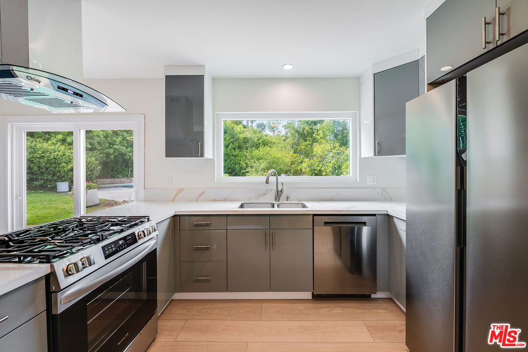 3643 Ballina Canyon Road Encino, CA 91436 - Photo 14 of 47 a kitchen with stainless steel appliances granite countertop a stove a refrigerator and a sink