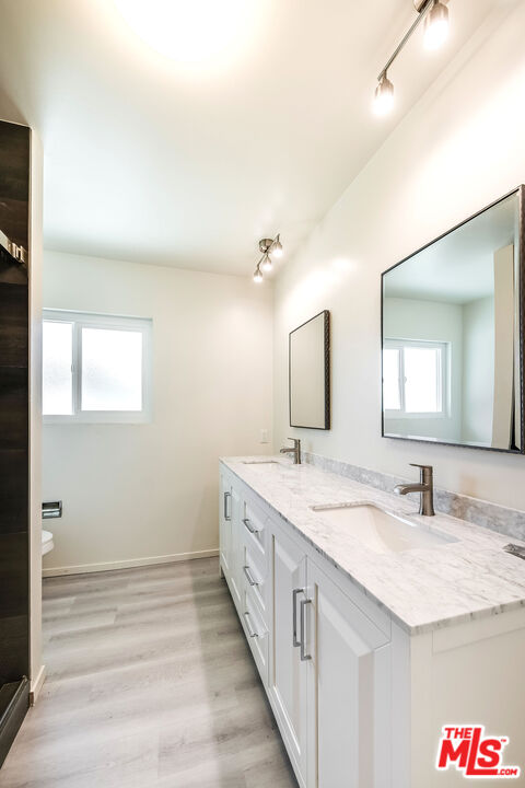 3643 Ballina Canyon Road Encino, CA 91436 - Photo 30 of 47 a bathroom with a granite countertop sink and a mirror