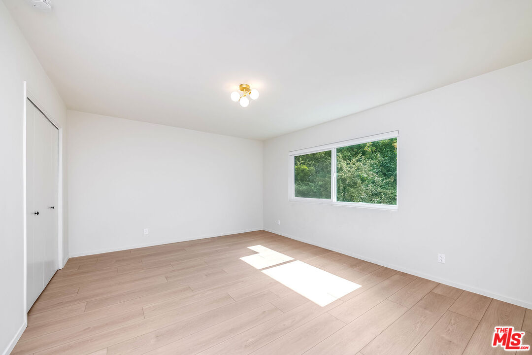 3643 Ballina Canyon Road Encino, CA 91436 - Photo 32 of 47 an empty room with wooden floor and windows