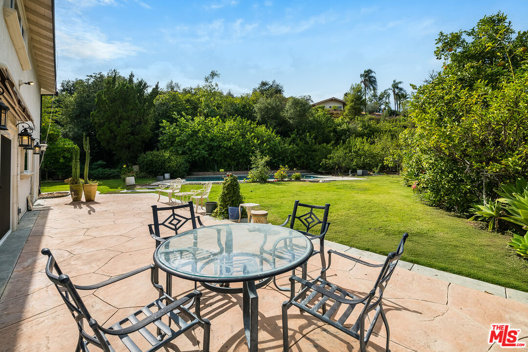 3643 Ballina Canyon Road Encino, CA 91436 - Photo 40 of 47 a view of a swimming pool with a table and chairs