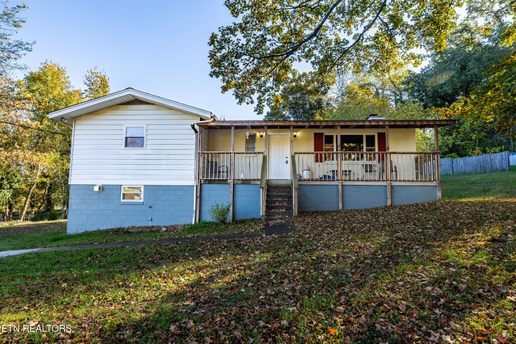 a front view of house with yard and trees in the background