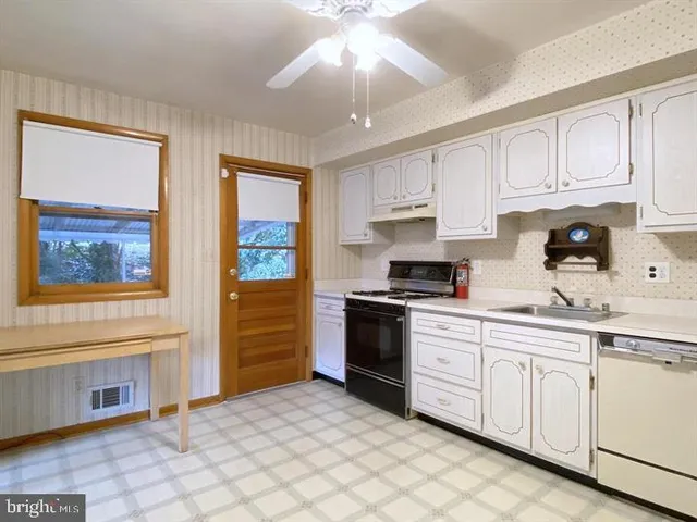 a kitchen with granite countertop a stove a sink and a refrigerator