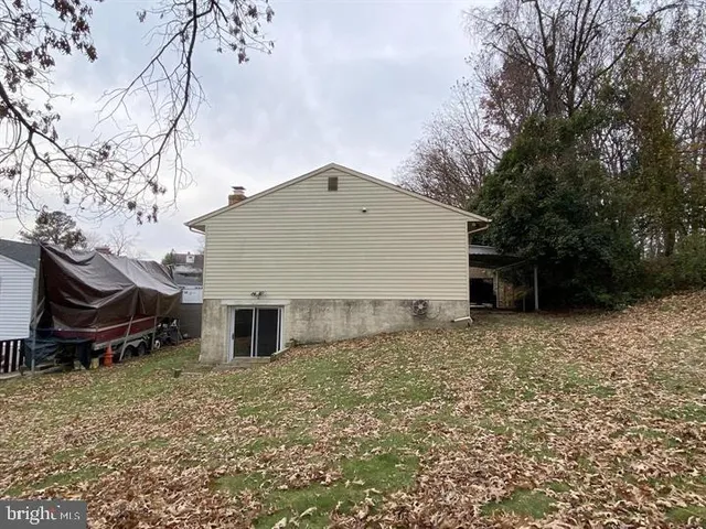 a view of a backyard with wooden fence and large trees