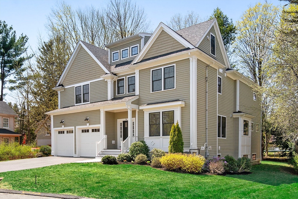 a view of a white house next to a yard and large trees