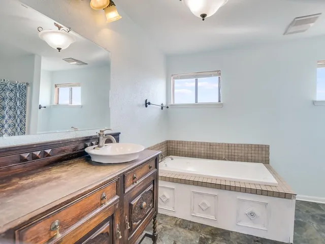 a bathroom with a granite countertop sink and a mirror