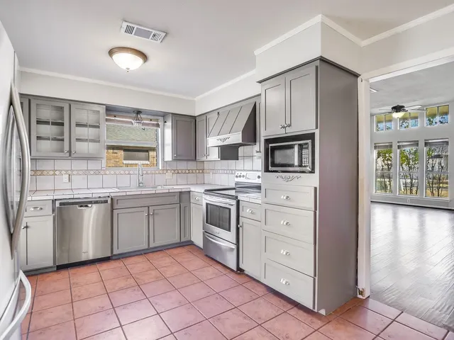 a kitchen with stainless steel appliances granite countertop a refrigerator and a stove top oven