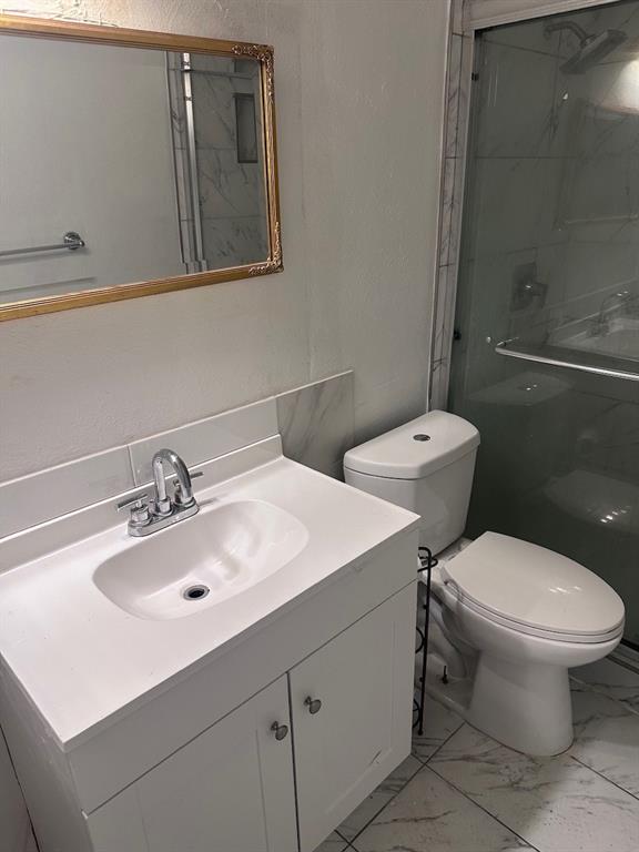 2103 Carlton Road Carrollton, TX 75007 - Photo 13 of 18 a white toilet sitting next to a bathroom sink