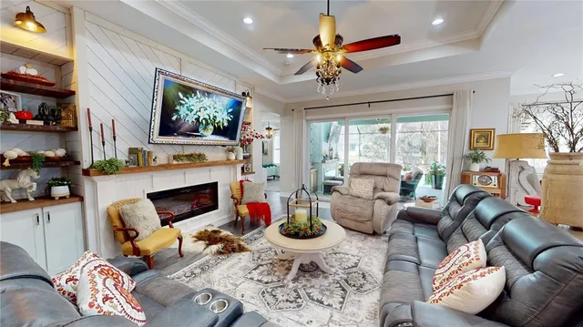 a living room with furniture kitchen view and a large window