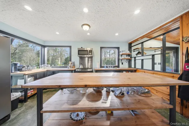 a living room with a table chairs and a refrigerator