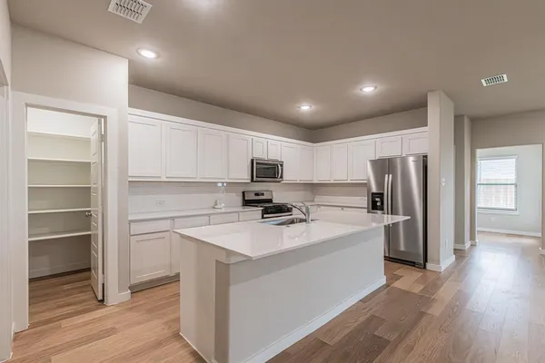 a kitchen with stainless steel appliances a refrigerator sink and microwave