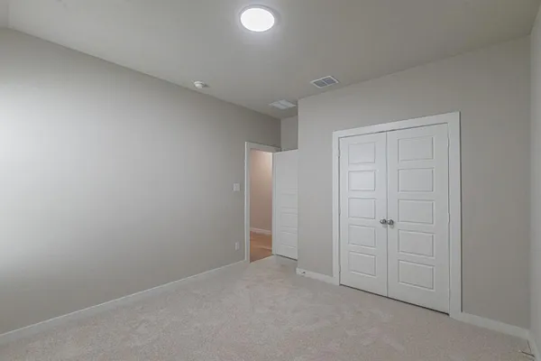 an empty room with windows and closet