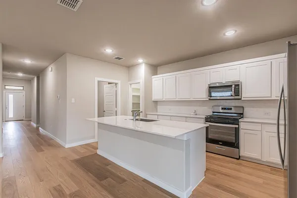 a kitchen with stainless steel appliances granite countertop a stove a sink and a refrigerator