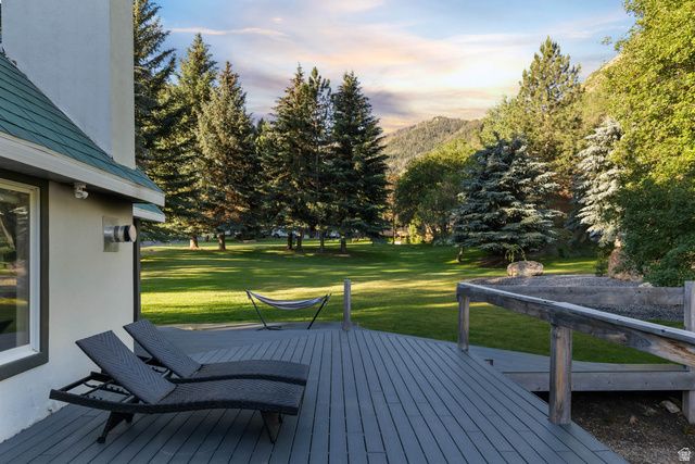 10686 South Covered Brg Cyn Road, Unit 14 Spanish Fork, UT 84660 - Photo 25 of 44 Spacious outdoor deck with composite decking and wood railing, overlooking a large grassy area with mature trees and mountain scenery